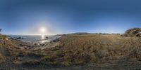 a fish eye view of an island with some rocks and a body of water near by