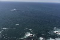 several people are parasailing over the ocean with one person on the airboard