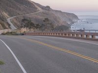 a motorcycle on the road near the water and hill top overlooking the ocean area in california