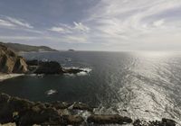 a view of the ocean from high on top of a cliff looking toward the ocean