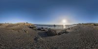 a 360 - view picture of the ocean at low tide with rocks and boulders in front of it