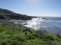 a view from the side of a hill at the edge of a beach that overlooks a river