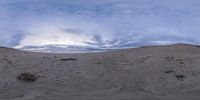 a panorama taken at low tide on the beach with clouds and sea in the background