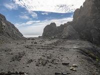 an ocean is seen in the background as it passes through rocks on the beach in this view