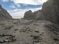 an ocean is seen in the background as it passes through rocks on the beach in this view