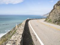 the road along the ocean is empty in most parts of california, and there's a lone person on one side