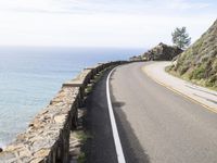 the road along the ocean is empty in most parts of california, and there's a lone person on one side