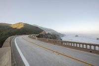 a view of a curvy road by the ocean in california state usa at sunset