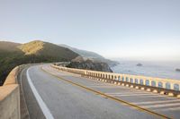 a view of a curvy road by the ocean in california state usa at sunset