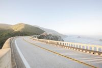 a view of a curvy road by the ocean in california state usa at sunset