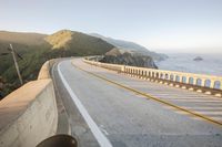 a view of a curvy road by the ocean in california state usa at sunset