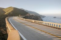 a view of a curvy road by the ocean in california state usa at sunset