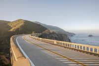 a view of a curvy road by the ocean in california state usa at sunset