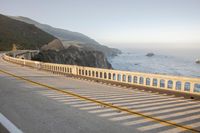 a view of a curvy road by the ocean in california state usa at sunset