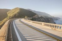 a view of a curvy road by the ocean in california state usa at sunset