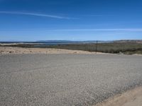 a paved beach with a fence in front of it and the ocean in the distance