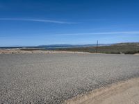 a paved beach with a fence in front of it and the ocean in the distance