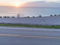 the view of a beautiful ocean from a viewpoint of a hill top and two people riding bikes