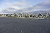 a gravel wall along the ocean is shown in this photo and is shown above an empty parking lot