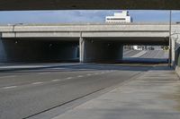 an underpass with cars on it leading to the other road from the tunnel near