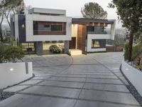 the exterior and landscape of a modern house in los angeles, california with stone and wood