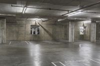 an empty parking garage with concrete floors and overhead lightings with no visible signs on the ceiling