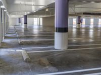 a large empty building that has rows of parking spaces on the floor and on pillars