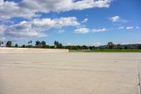 a person is walking down a street past an empty parking lot on the corner in the middle of the sky