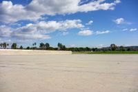 a person is walking down a street past an empty parking lot on the corner in the middle of the sky