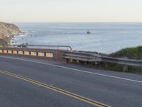 a street view of a beautiful oceanfront with yellow line markings in the road area