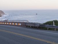 a street view of a beautiful oceanfront with yellow line markings in the road area