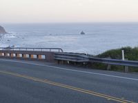 a street view of a beautiful oceanfront with yellow line markings in the road area