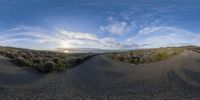 the sky is reflected in this fish eye lens photograph of the road winding through the fields