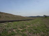 the empty highway stretches right over a grassy hill to the horizon, in this case an airplane