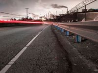 a highway with a sky view and two white fire trucks driving down it and smoke billowing into the sky