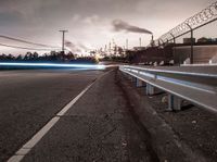 a highway with a sky view and two white fire trucks driving down it and smoke billowing into the sky