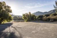 the sun is shining over the mountains in this empty parking lot at the resort's campground site