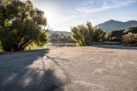 the sun is shining over the mountains in this empty parking lot at the resort's campground site