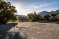 the sun is shining over the mountains in this empty parking lot at the resort's campground site