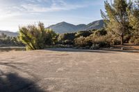 the sun is shining over the mountains in this empty parking lot at the resort's campground site