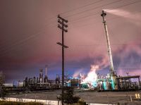 a factory with a lot of smoke going into it on a cloudy night of day