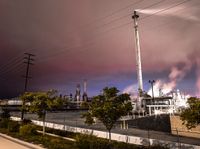 a factory with a lot of smoke going into it on a cloudy night of day