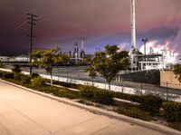 a factory with a lot of smoke going into it on a cloudy night of day