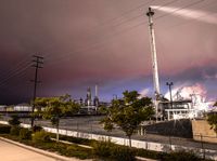 a factory with a lot of smoke going into it on a cloudy night of day