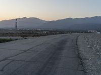 an empty city street near a large mountain range with a few hills in the distance