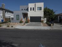 a home sits on the corner of a street with blue bins and gravel driveway