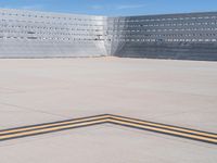 an empty parking lot with large concrete stands in the foreground and a single striped yellow line running across the cement