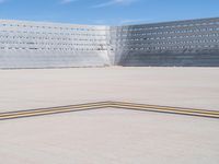 an empty parking lot with large concrete stands in the foreground and a single striped yellow line running across the cement