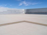 an empty parking lot with large concrete stands in the foreground and a single striped yellow line running across the cement