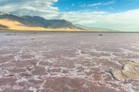 an area with mountains, rocks and water in the middle of the desert with sparse grass